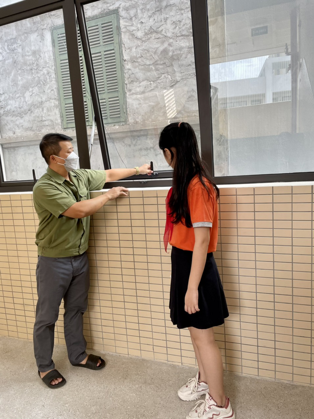 Two people standing in front of a window
Description automatically generated with low confidence