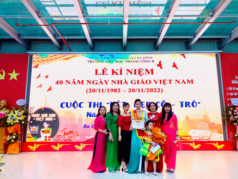 A group of women posing for a photo in front of a banner
Description automatically generated with medium confidence