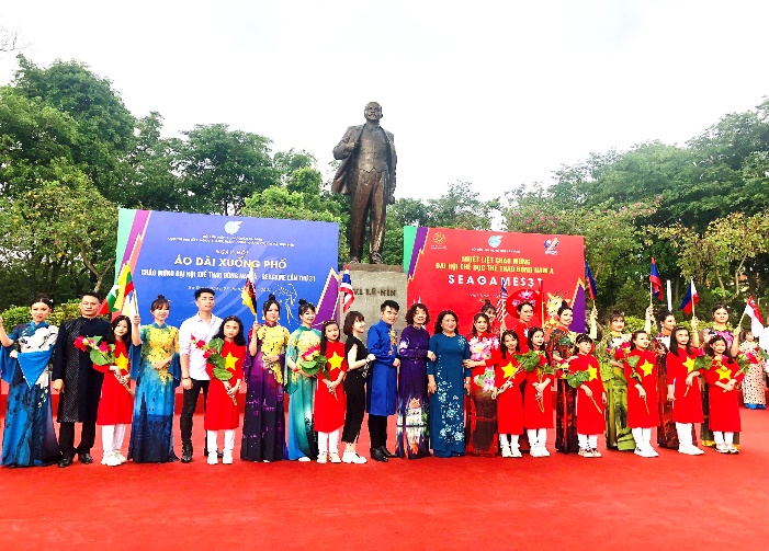 A group of people posing for a photo in front of a statue

Description automatically generated