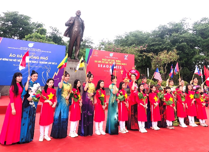 A group of people in red and blue dresses standing in front of a statue

Description automatically generated with low confidence