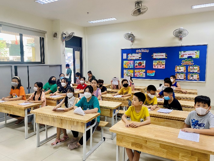 A group of children sitting at desks in a classroom
Description automatically generated with medium confidence