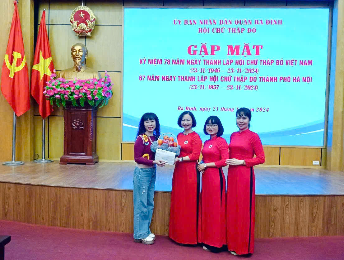 A group of women standing in front of a large screen
Description automatically generated
