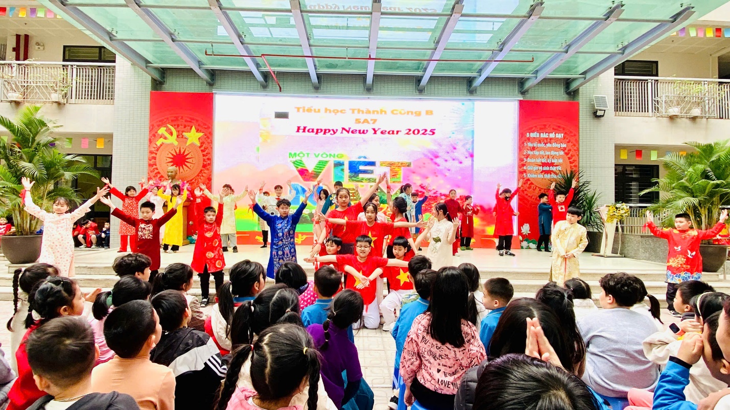 A group of children performing in a room with a large crowd

Description automatically generated