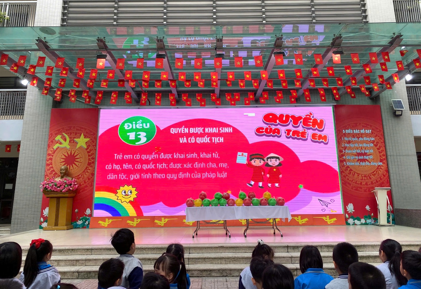 A stage with a large screen and a group of people watching
AI-generated content may be incorrect.