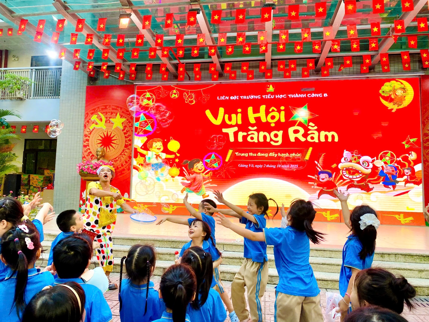 A group of children in front of a stage
Description automatically generated