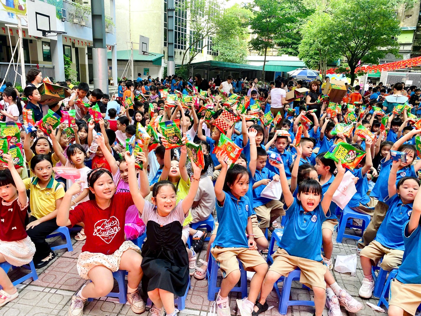 A group of children sitting on blue chairs
Description automatically generated