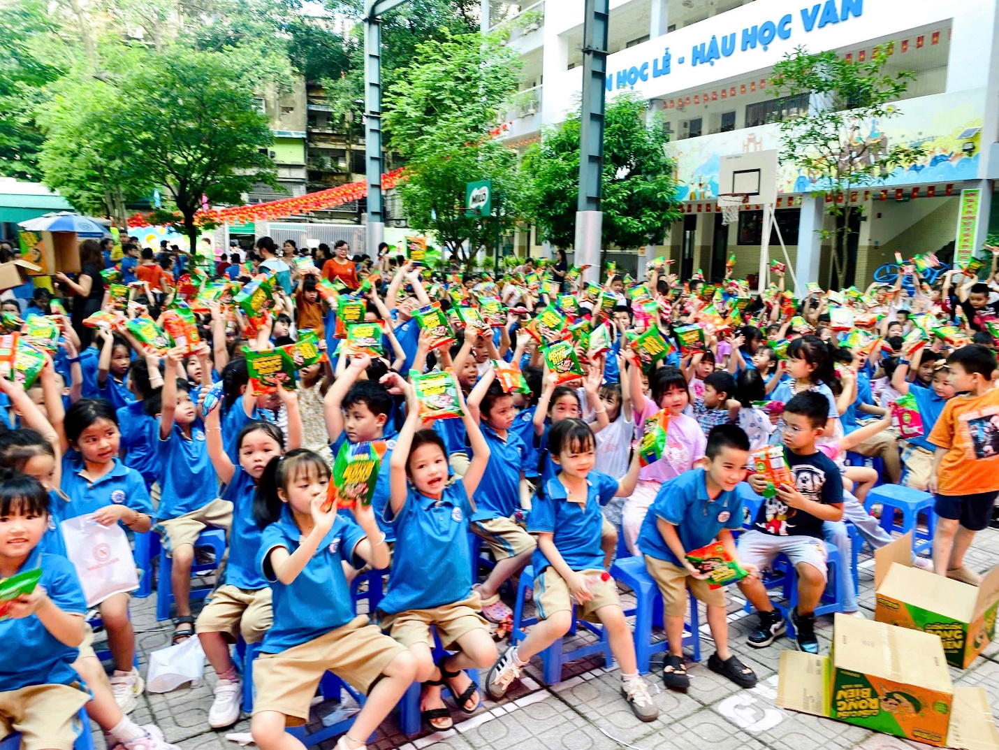 A group of children sitting on blue chairs
Description automatically generated