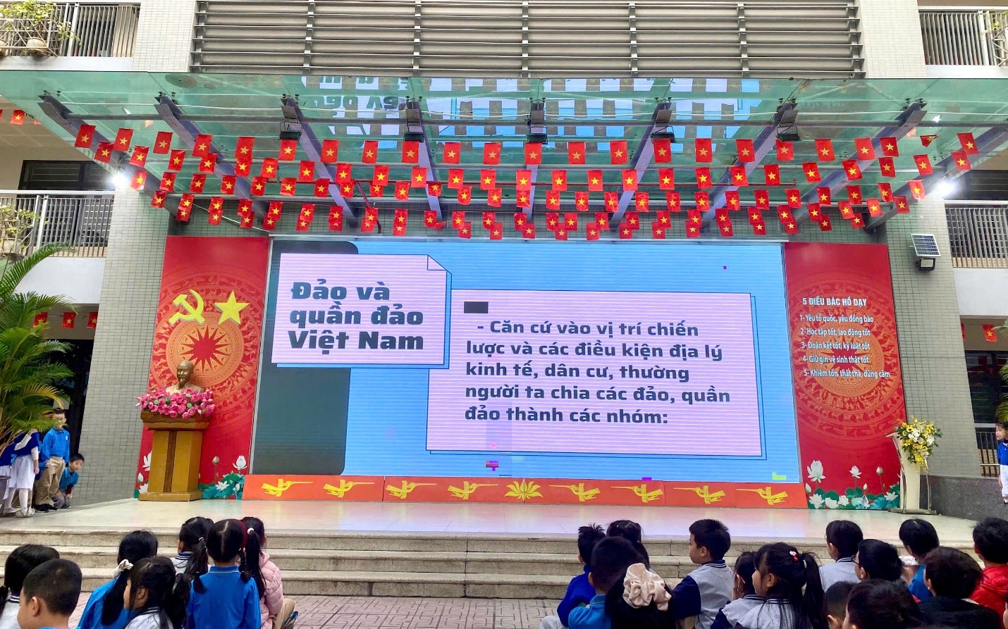 A group of children sitting in front of a stage
AI-generated content may be incorrect.