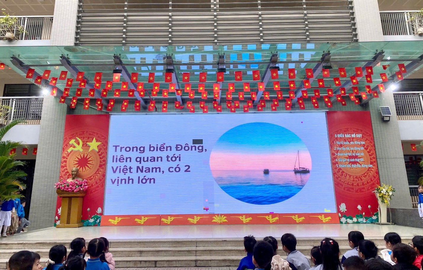 A stage with a large screen and a group of people
AI-generated content may be incorrect.