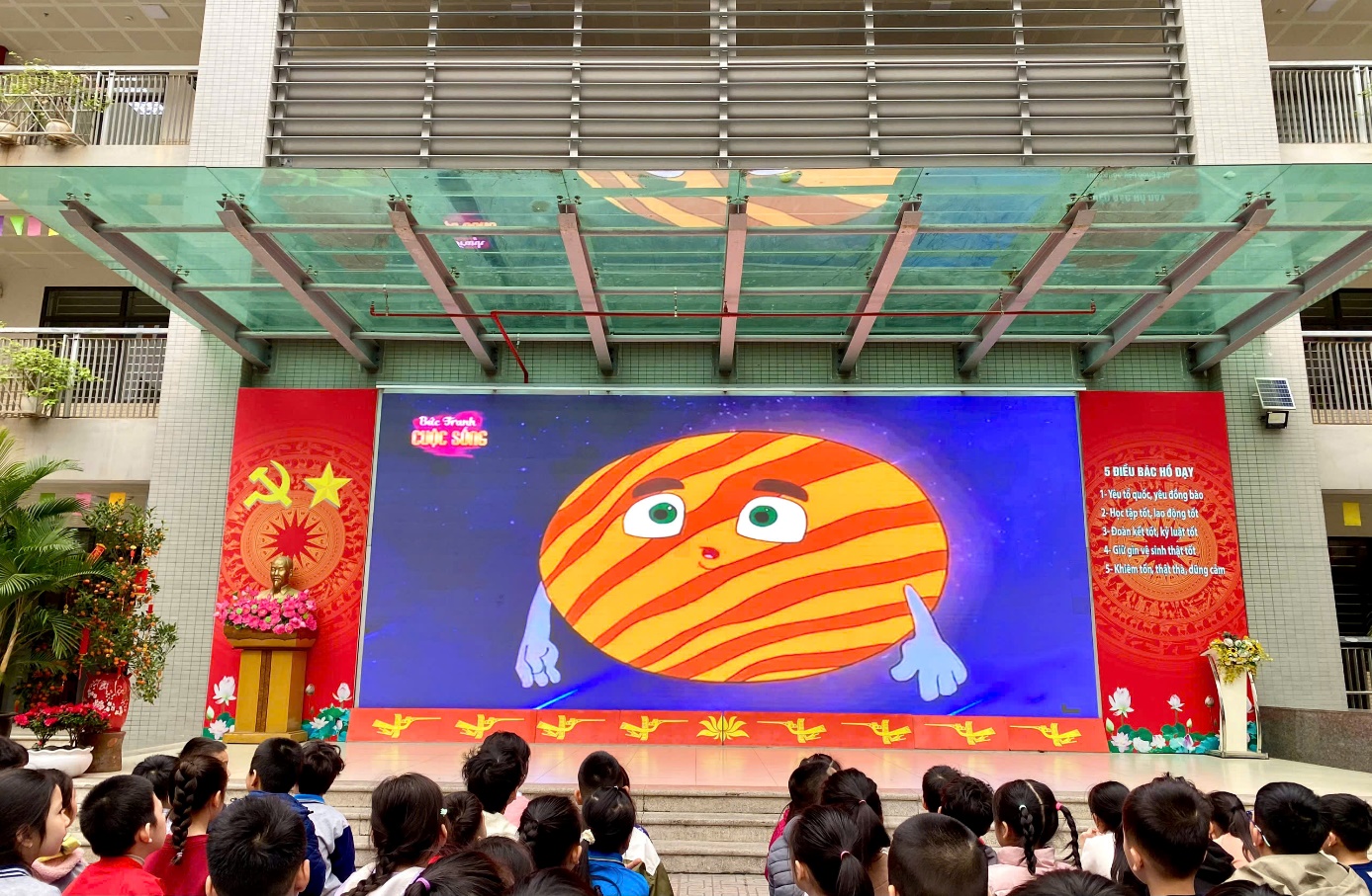 A group of people looking at a large screen
Description automatically generated