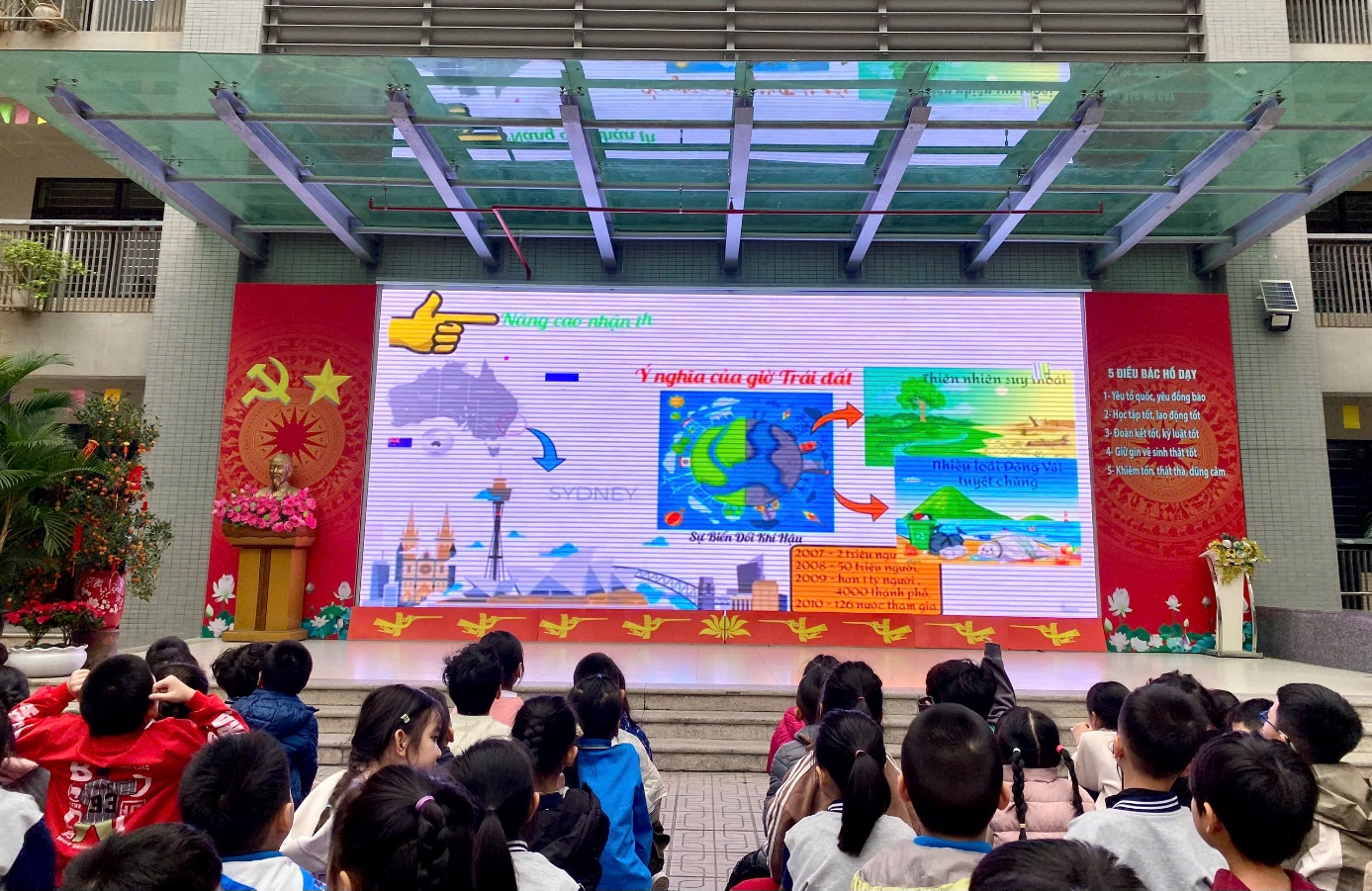 A group of children in front of a large screen
Description automatically generated