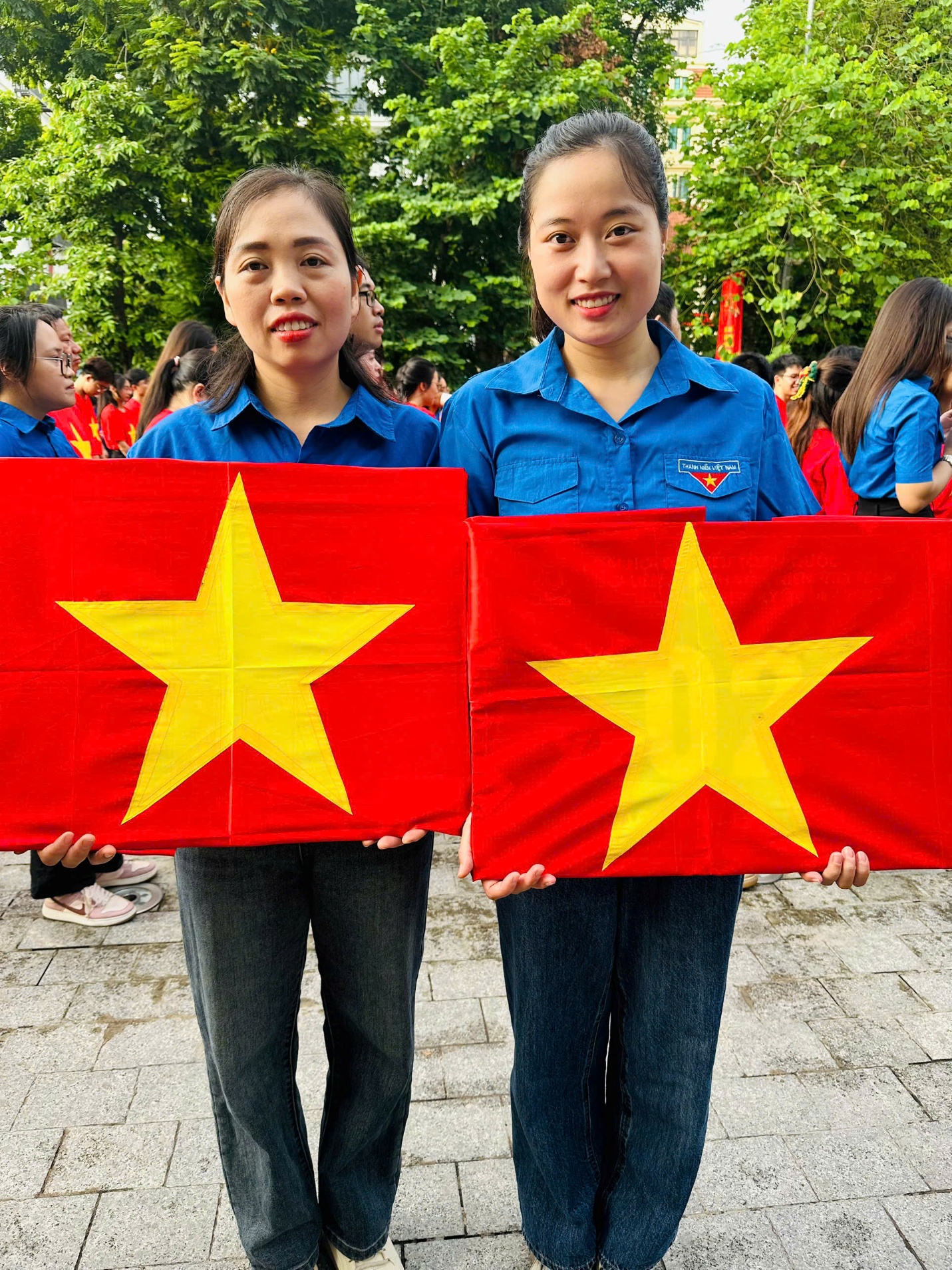 Two women holding up red signs with yellow stars
AI-generated content may be incorrect.