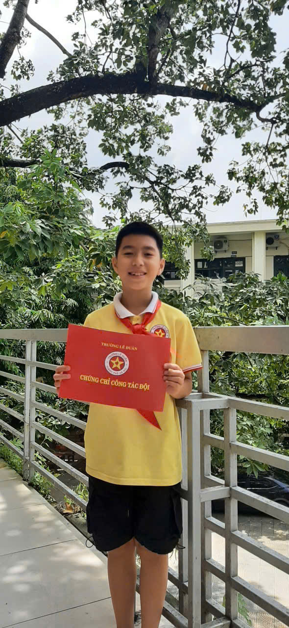 A child holding a red paper
Description automatically generated