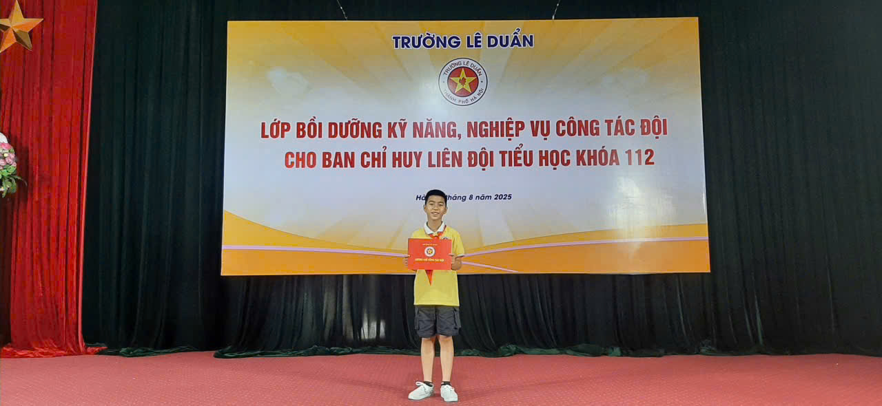 A person standing on a stage holding a certificate
Description automatically generated