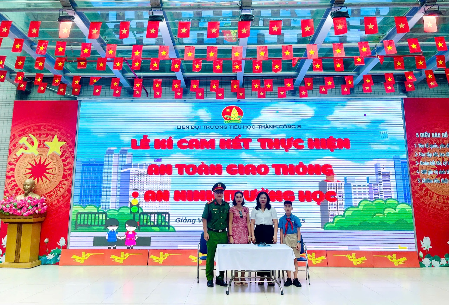 A group of people standing in front of a large banner
Description automatically generated